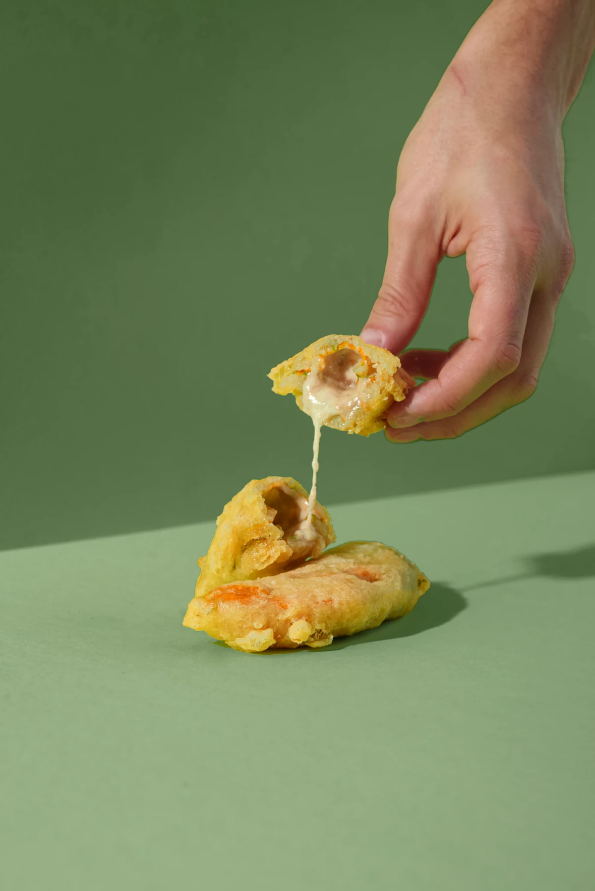 Fiore di zucca in pastella aperto, con ripieno di mozzarella e alici