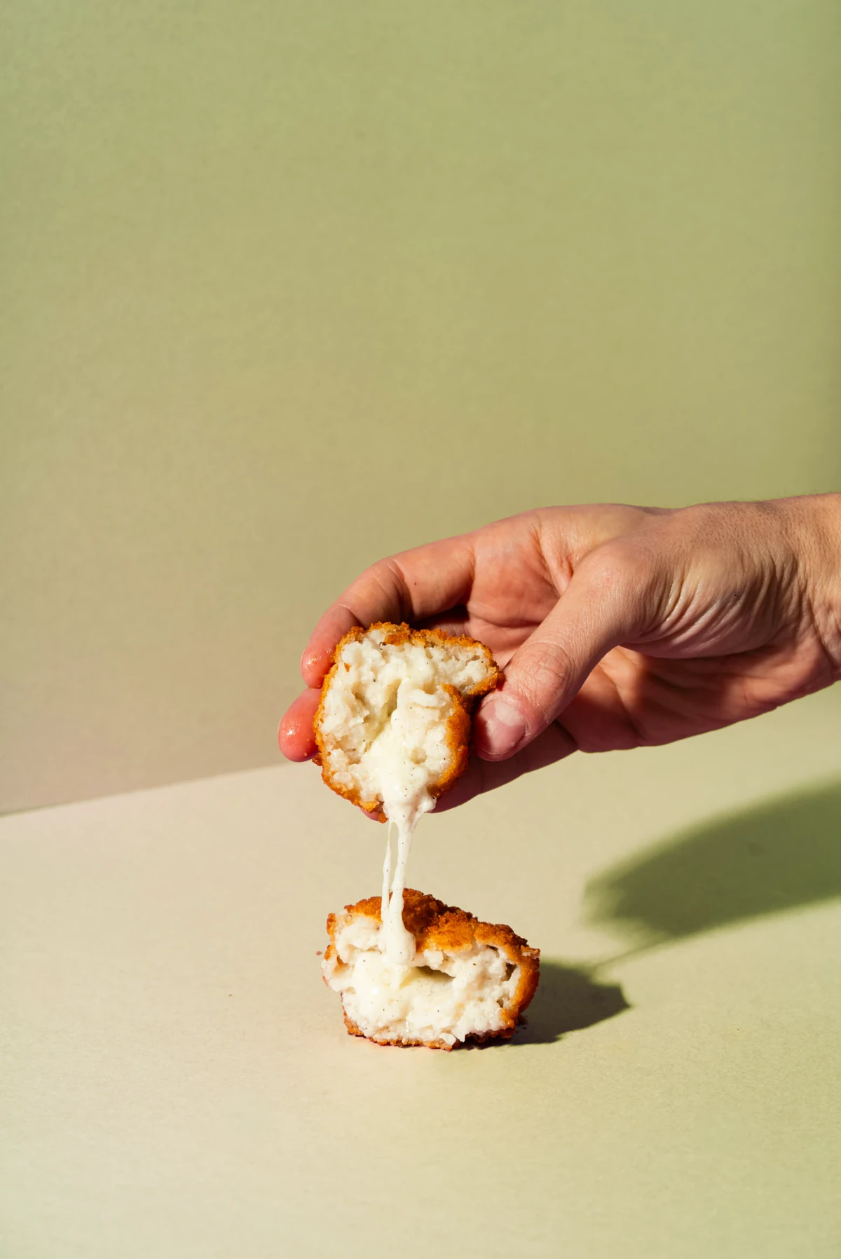 Supplì cacio e pepe da 100 g aperto, con cuore morbido di crema di pecorino